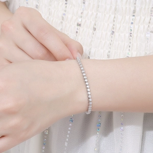 Elegant 2mm moissanite sterling silver tennis bracelet worn by a female model on wrist
