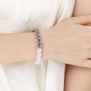 Detail of beaded bracelet with silver steel beads and imitation pearls on wrist