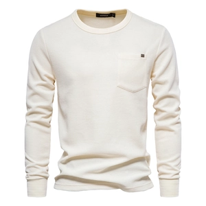 Close-up of waffle texture cotton fabric with chest pocket and round neck on beige shirt