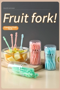 Close-up of colorful plastic fruit forks with cute handles in transparent storage tubes