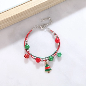 Close-up of a Christmas bracelet featuring enamel tree charm and festive woven cords
