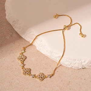 Détail du bracelet trèfle doré avec zircons pavés et fermoir coulissant réglable