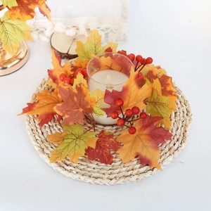 Macro shot of maple leaves and red berries candle ring with glass holder for autumn decor