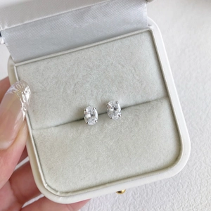 Macro shot of oval-cut zircon earrings in a velvet jewelry box showing detail
