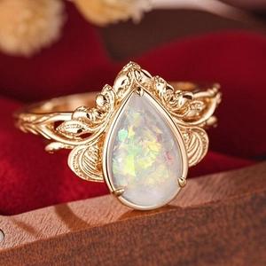 Macro shot of vintage gold leaf ring with pear-shaped opal and intricate hollow texture