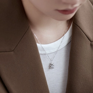 Close-up of a sparkling silver bear pendant set with white zircon on a delicate chain