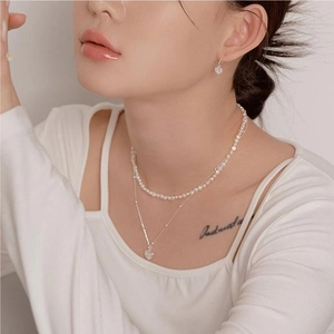Detail of 925 sterling silver heart earrings and double-layer pearl heart necklace set