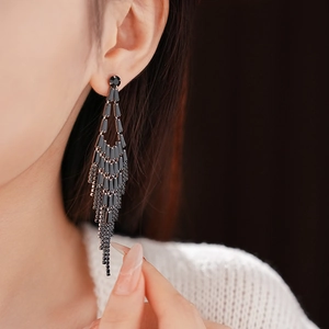 Close-up of long black rhinestone tassel earrings worn on model for fashion styling