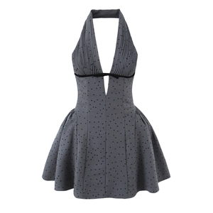 Grey halter dress with black polka dots, deep V-neck, high waist, and pleated bodice details