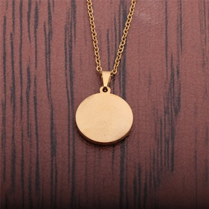 Minimalist round gold titanium steel pendant necklace on a dark brown wood background