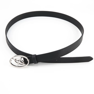 Detail of thin black leather belt with silver oval buckle featuring a cutout star motif