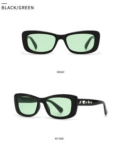 Detail view of small square black sunglasses with green lenses and rhinestone temples
