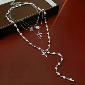 Three-layer silver beaded necklace with white pearls, cross pendants and sacred medals