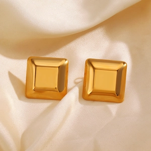 Minimalist square stainless steel stud earrings in gold on beige silk background