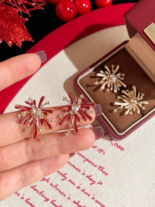 Detail view of firework earrings with red and white enamel and sparkling rhinestones