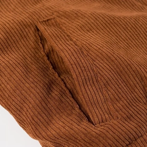 Makroaufnahme der braunen Cordstoff-Textur und der Taschennähte an der Jacke