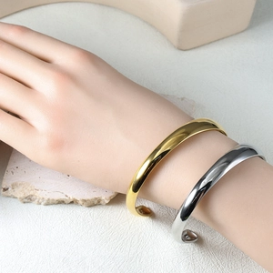 Polished minimalist gold and silver stainless steel open C-shape cuff bracelets on model