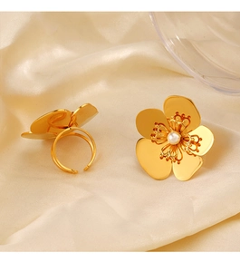 Détail d'une bague fleur plaquée or 18 carats avec perle sur fond en soie crème