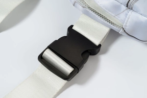 Macro detail of white woven strap with durable black plastic buckle and metal zipper