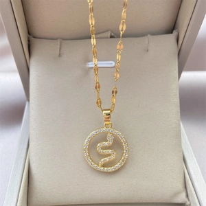 Detail showing 18K gold snake pendant with sparkling zircons in a luxury gift box