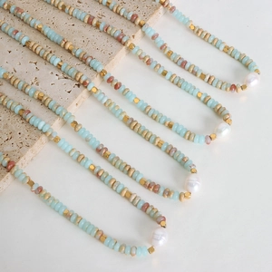 Vintage beaded pearl necklace with baroque pendant and natural stone beads on a stone tray