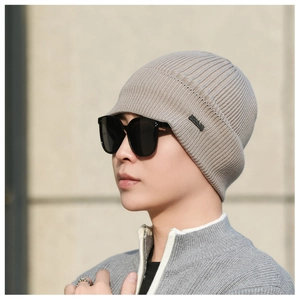 Close-up of khaki winter knit beanie with vertical ribbed texture and logo patch