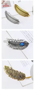 Detailed close-up of golden and silver feather hair clips with pearls and gems