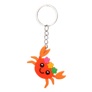 Detailed close-up of a cute orange PVC crab keychain with colorful floral decorations