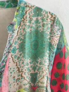 Gros plan du col en V et des motifs floraux colorés sur une robe en tissu léger