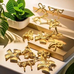 Detail of gold-plated stainless steel bow pendants for DIY jewelry and necklaces