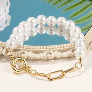 Detailed shot of baroque pearl bracelet with gold spring clasp on vintage mirror