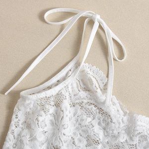 Détail de la broderie florale en dentelle blanche sur la robe avec bretelles assorties