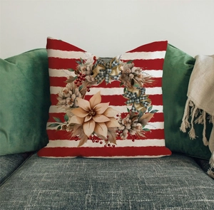 Close-up of Christmas pillow cover with floral wreath on red and white striped fabric
