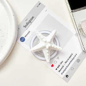 Close-up of white starfish phone griptok with textured resin detail on white background