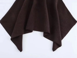 Détail de l'ourlet asymétrique en maille marron foncé avec une texture de laine douce