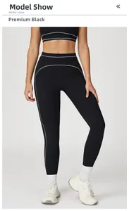 Detail of high-waist black yoga leggings with contrast white stitching for contouring