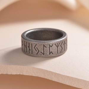 Macro detail of Nordic Viking runes engraved on a vintage matte titanium steel ring