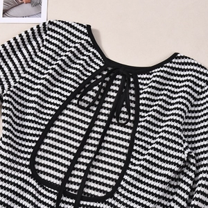 Détail de l'encolure d'une robe rayée montrant la texture en maille et le nœud au dos