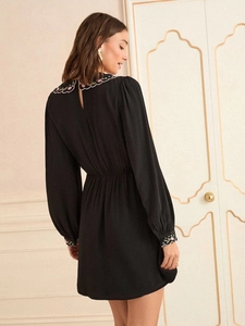Elegant black long-sleeved dress with floral embroidery and classic high waist A-line cut
