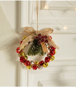 Christmas wreath detail with red gold silver bells burlap bow and pine needles decor