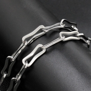 Macro view of silver wave-shaped geometric chain link necklace on black display
