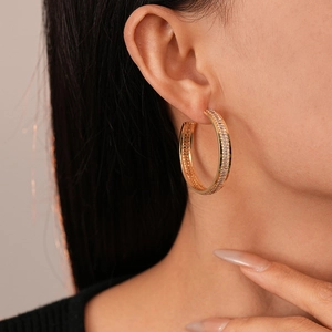 Side view of gold hoop earrings with baguette-cut cubic zirconia on a female model