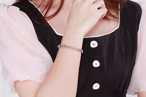 Detail of silver infinity symbol stainless steel chain bracelet worn on female wrist