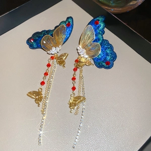 Détails de boucles d'oreilles papillon brodées avec zircons et glands perlés
