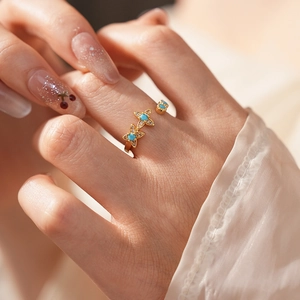 Vue détaillée d'une bague fleur vintage en or avec turquoise et zircon sur la main