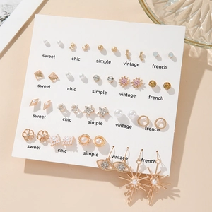 Macro detail of mixed gold earrings set featuring faux pearls and sparkling rhinestones