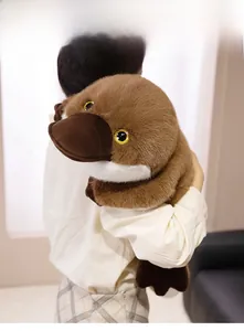 Close-up of a soft brown platypus plush toy being held to show texture and large size