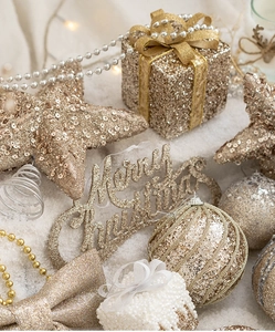Close-up of champagne gold glitter Christmas ornaments and Merry Christmas plaque