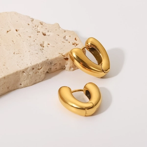Polished 18K gold plated stainless steel heart hoop earrings on beige stone base