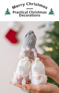 Close-up of three knitted Christmas gnomes with silver snowflake sequins being held by hand
